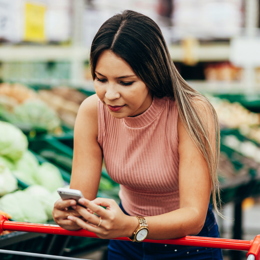 woman with a shopping cart on her cell phone