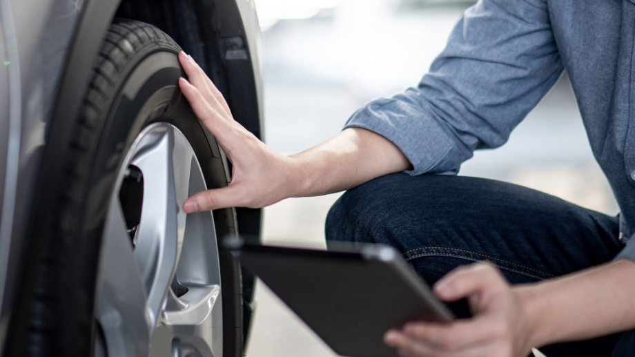 checking a tire with a tablet in the hand