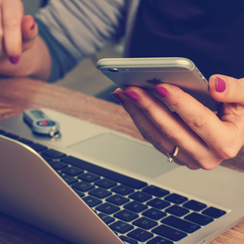 woman browsing a phone and a laptop