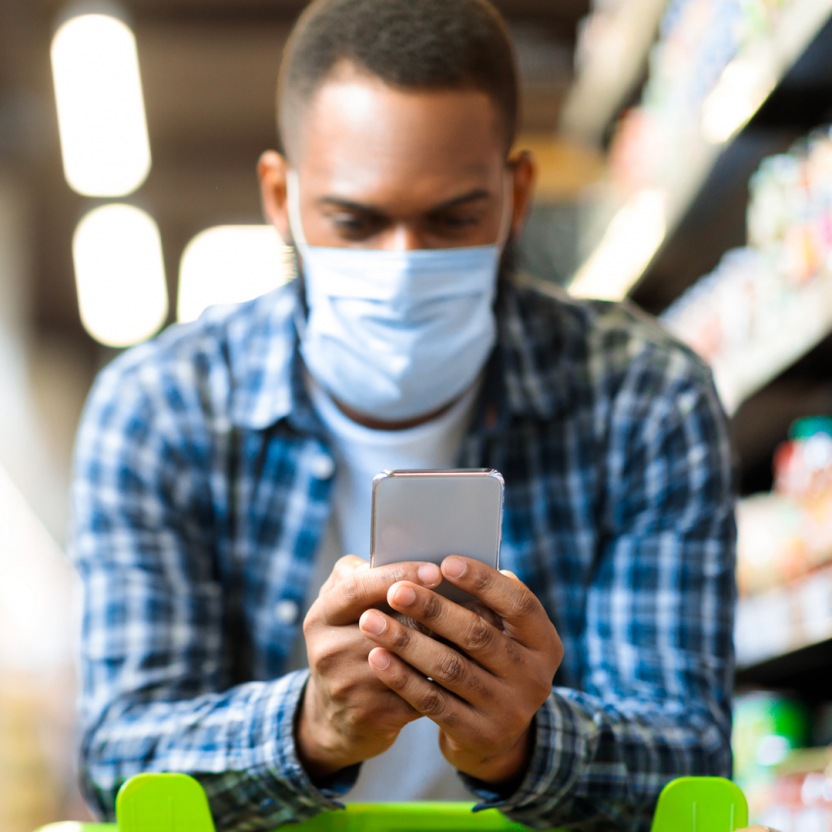 man browsing his phone while shopping