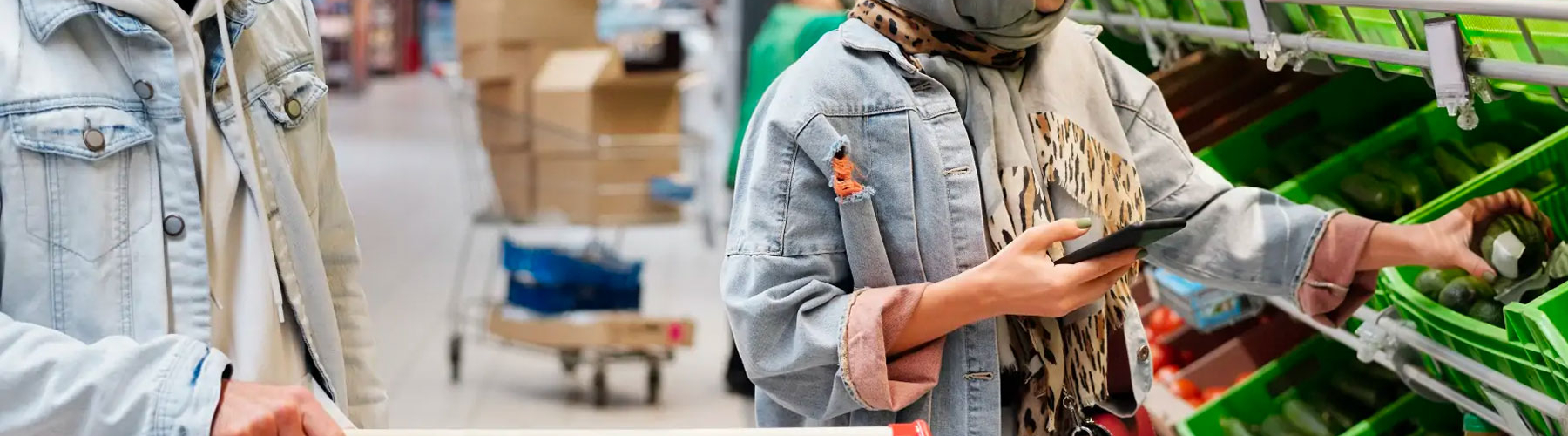 woman doing groceries with a phone in hand