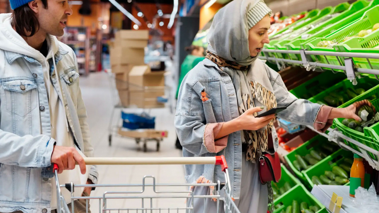 woman doing groceries with a phone in hand