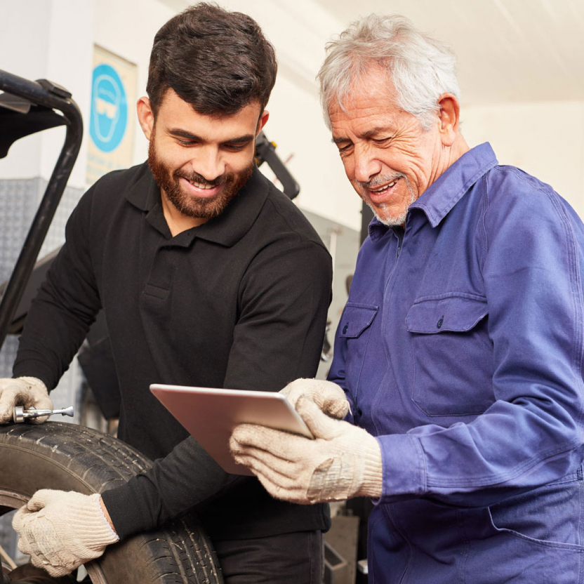 tire technician showing something to a colleague on a tablet