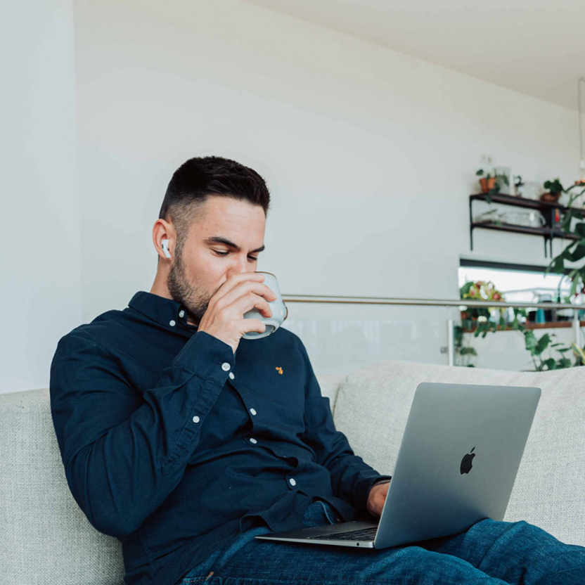 Man using a computer while sitting on a sofa