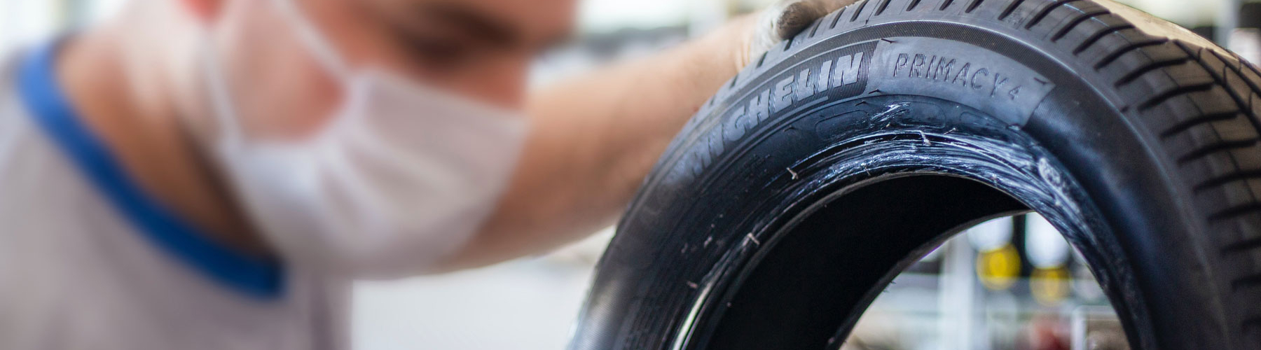 tire technician holding a michelin tire