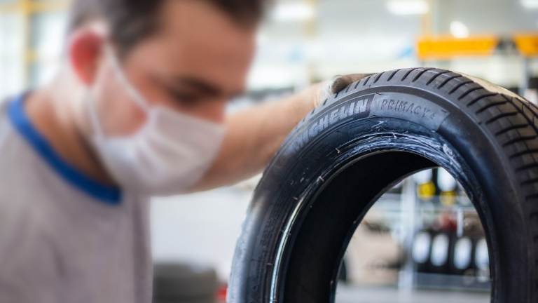 tire technician holding a michelin tire