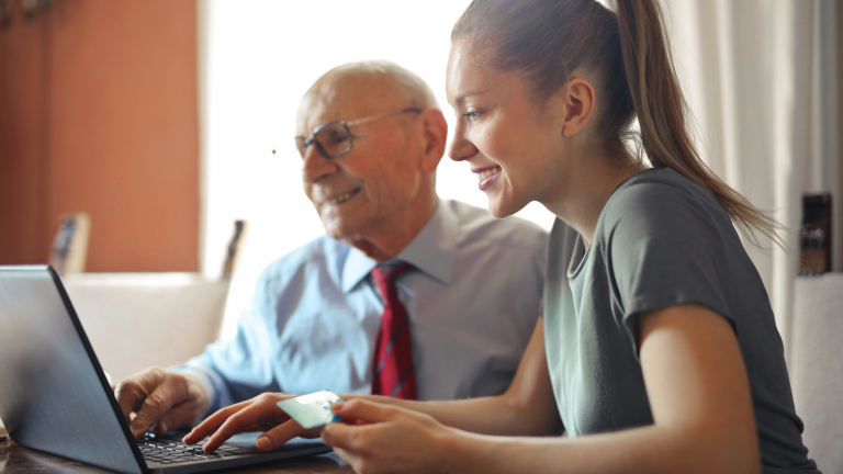 man and woman sitting in front of computer