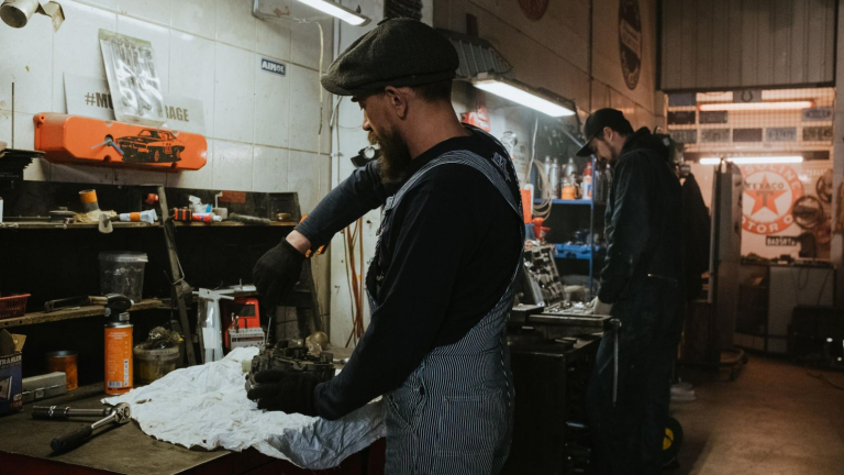 man repairing a vehicle part in a service