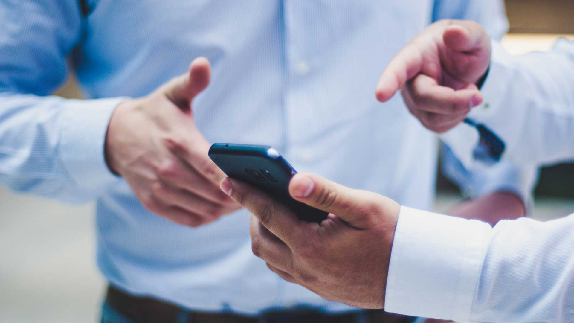 Two man in shirt pointing to a mobile phone