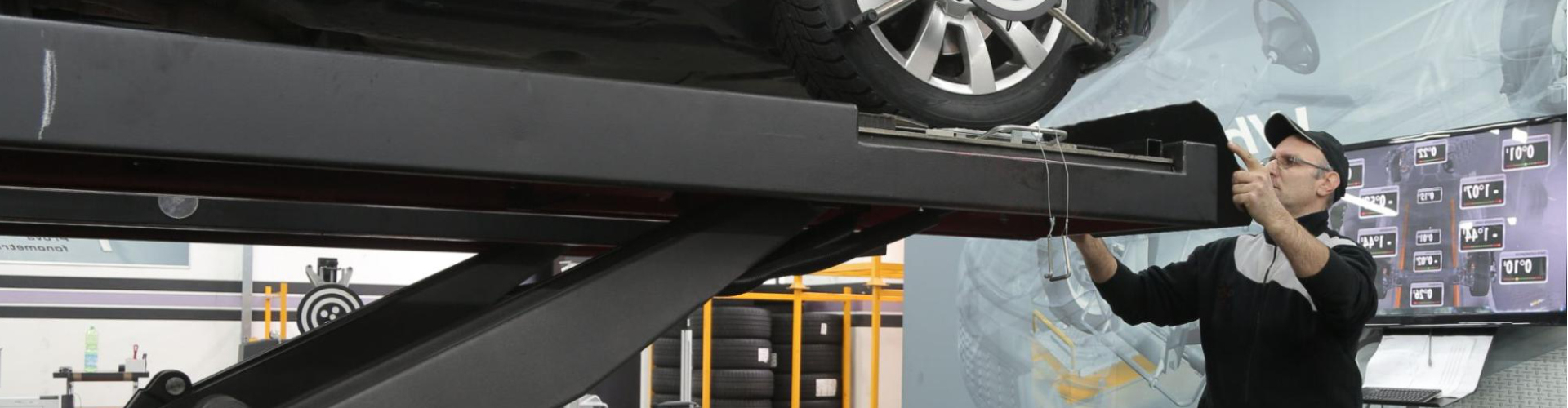 A man inspecting a vehicle in a service