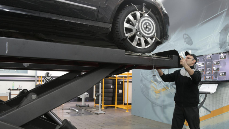 A man inspecting a vehicle in a service