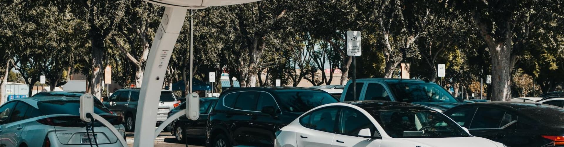 Tesla parking next to a charging station with solar panels