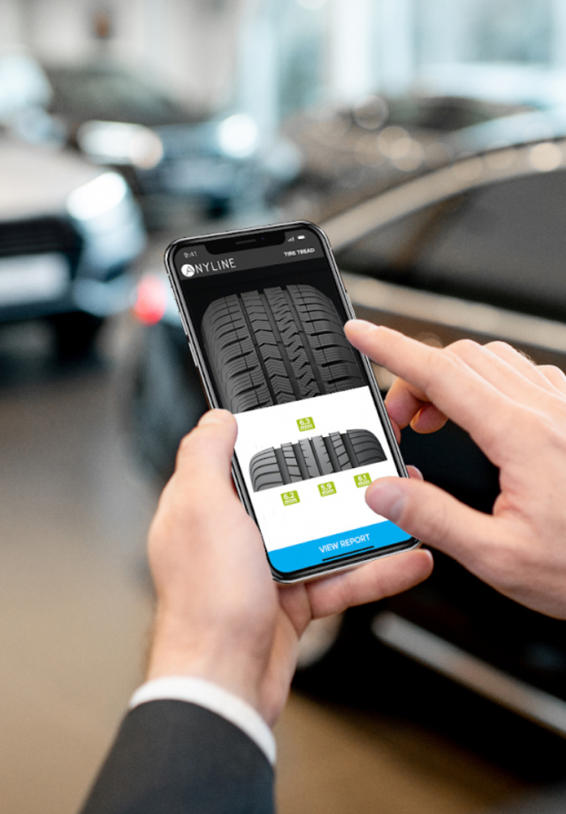 man holding smartphone tire tread on screen