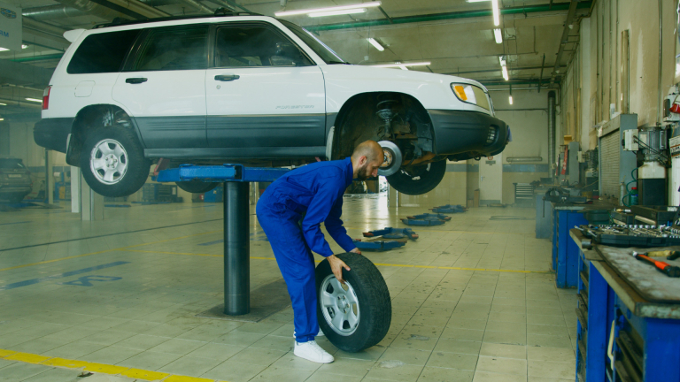 technician changing tire on car