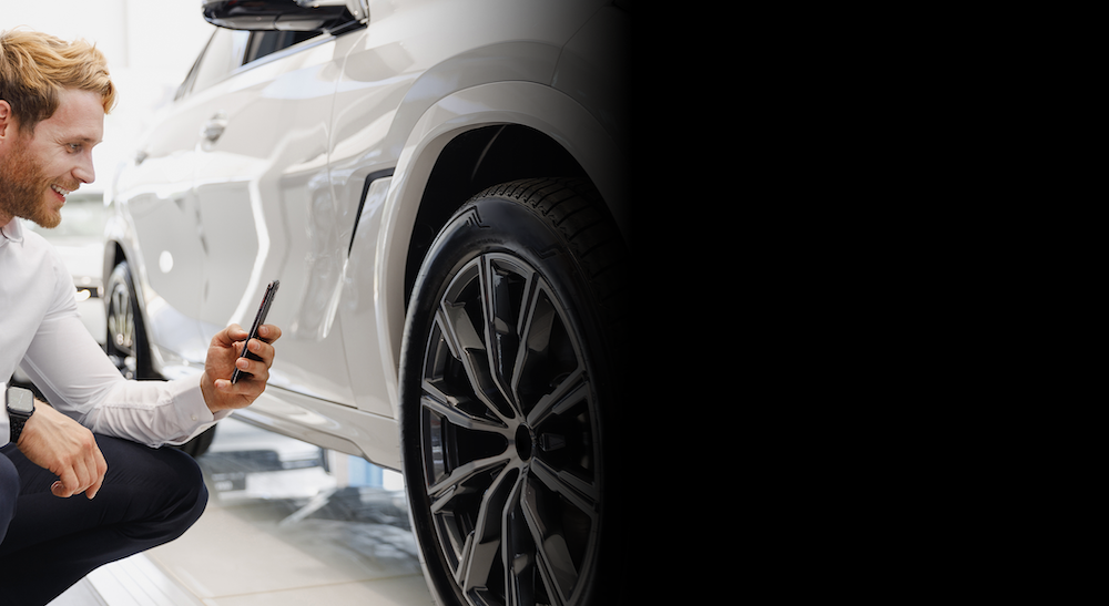 man scanning a tire in a car rental shop