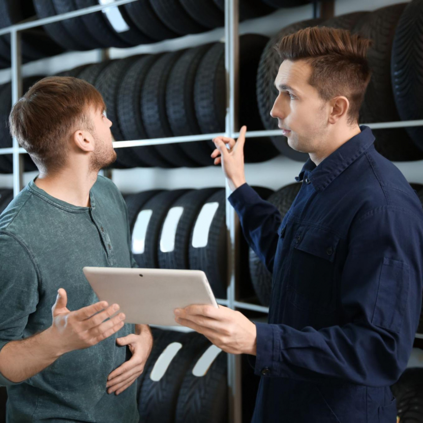 Technician with customer choosing tire for vehicle