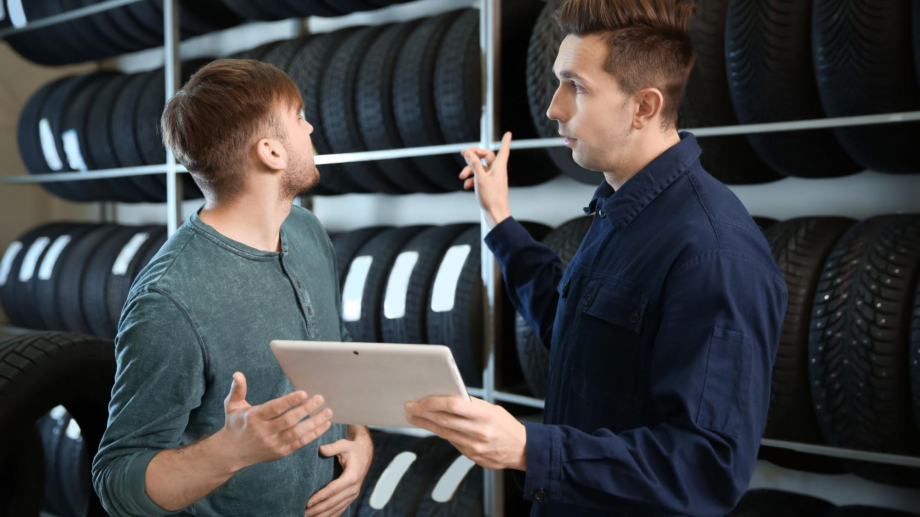 Technician with customer choosing tire for vehicle