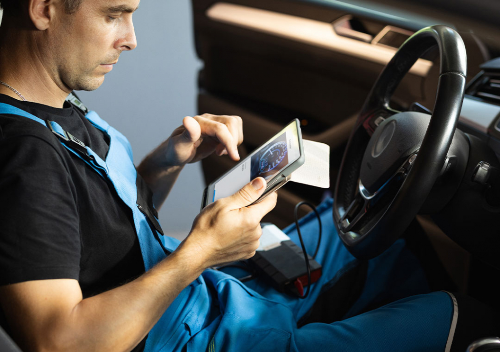 Technician checking the odometer just scanned with a tablet