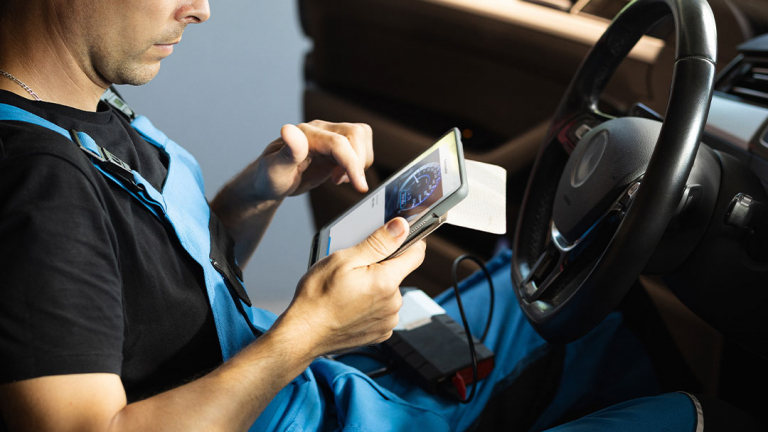 Technician checking the odometer just scanned with a tablet