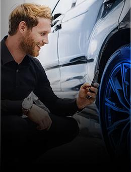 A man scanning a tire with a smartphone