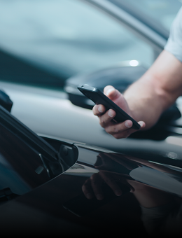 A man scanning a VIN on a windshield with a smartphone