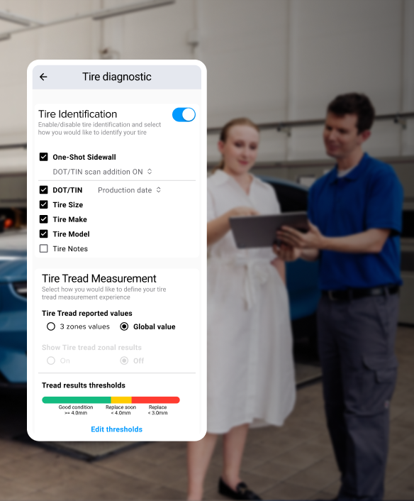 A technician showing a customer the results of a tire inspection on a tablet and visual representation of the data provided