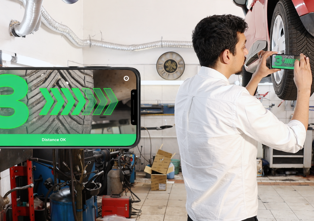AI in real-world conditions. Man measures Tire Tread depth with AI-Powered mobile device.
