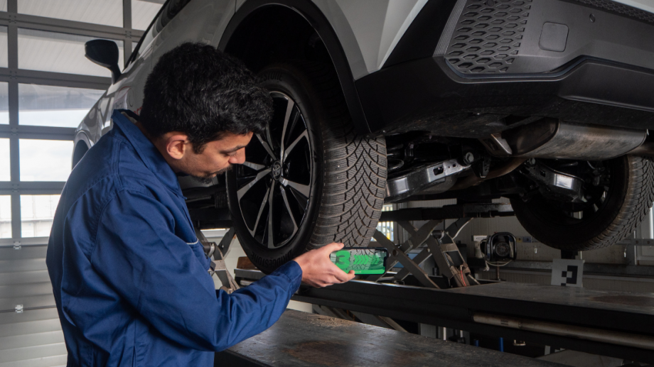 Automotive mechanic scanning tire tread with mobile device TireBuddy App