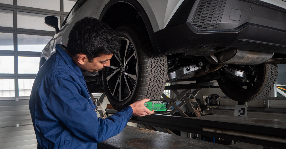 Automotive mechanic scanning tire tread with mobile device TireBuddy App