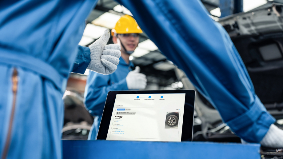 Technicians inspecting tires with a tablet